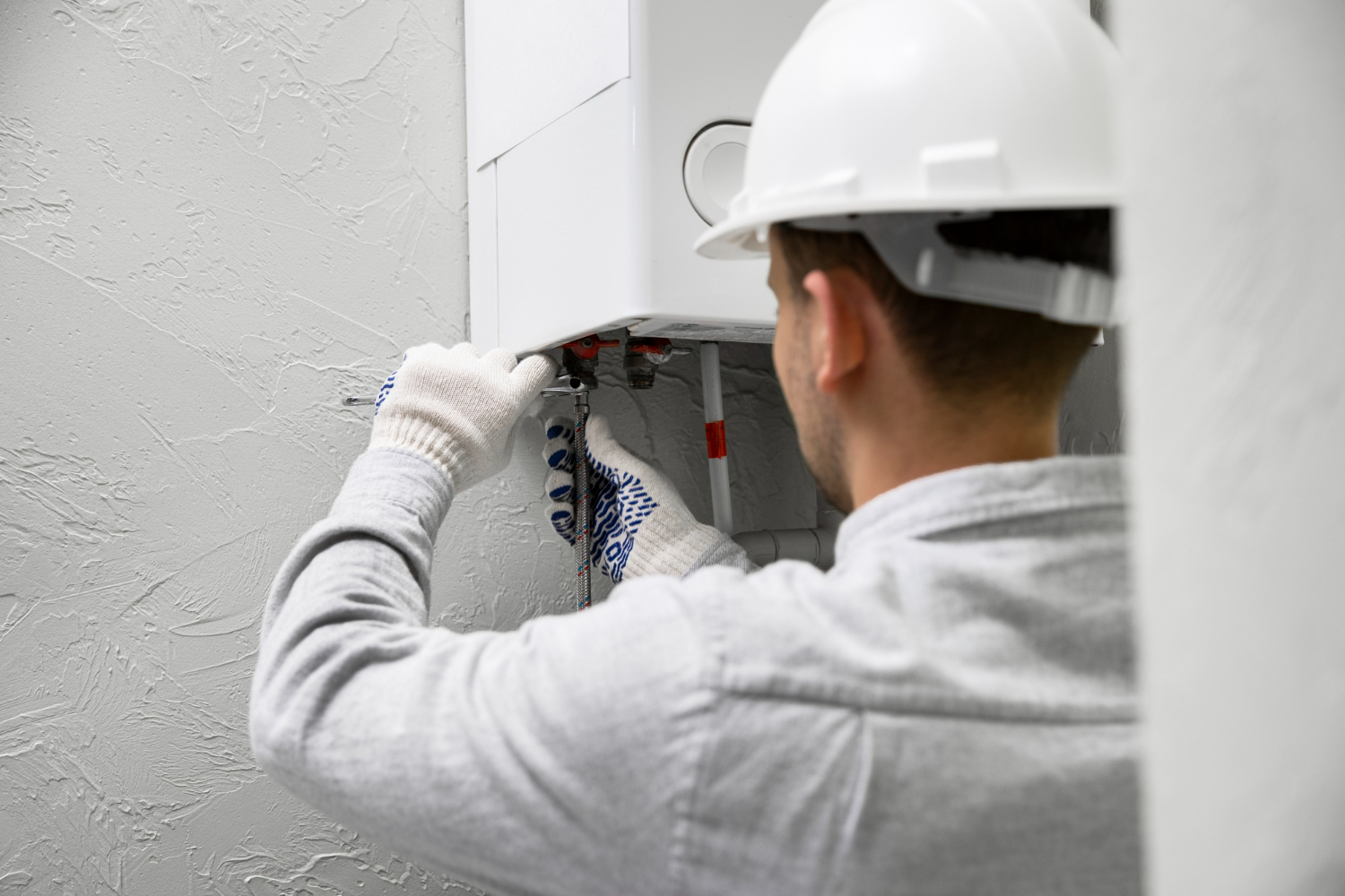 Technicien plagnol entretenant une chaudière murale gaz en intérieur à langon