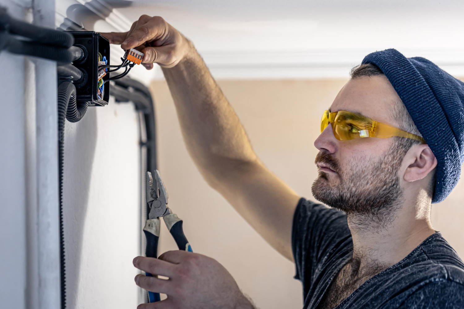 Électricien plagnol à langon réalisant un câblage soigné et sécurisé dans une pièce lumineuse